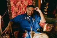 a man with dreadlocks sitting in a chair